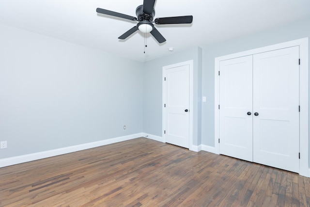 unfurnished bedroom featuring ceiling fan, a closet, wood finished floors, and baseboards