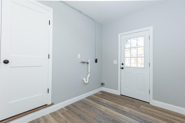 clothes washing area featuring laundry area, baseboards, and wood finished floors