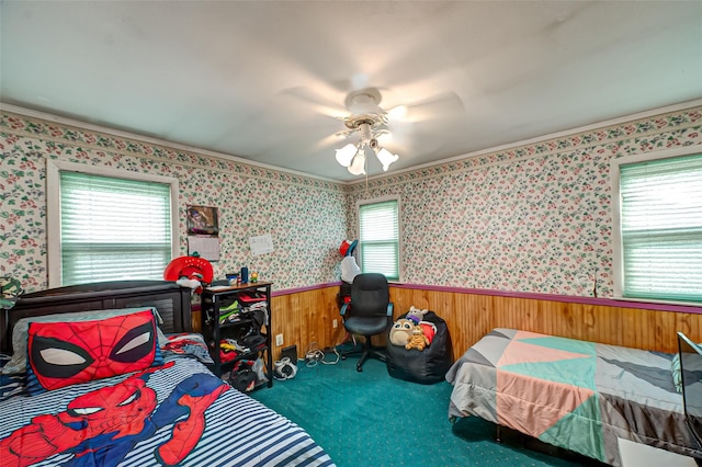 bedroom featuring wallpapered walls, multiple windows, and wainscoting