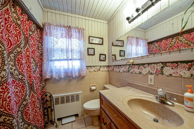 full bathroom featuring tile walls, toilet, radiator heating unit, vanity, and tile patterned floors