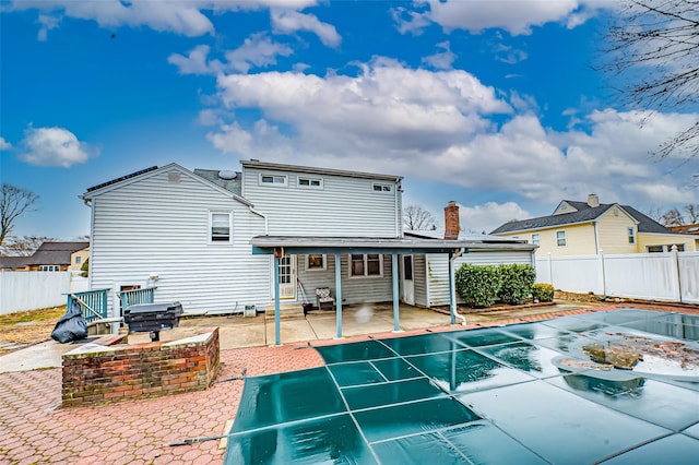 rear view of house with entry steps, a patio area, and a fenced backyard