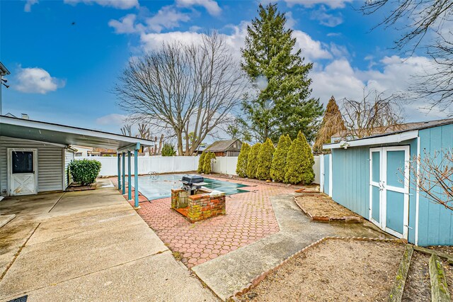 view of patio with a storage shed, a fenced backyard, and an outdoor structure