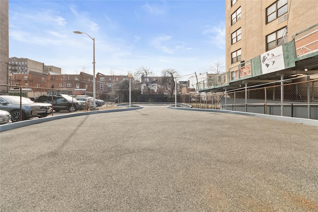 view of vehicle parking featuring fence