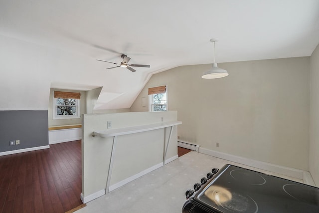 kitchen featuring lofted ceiling, baseboard heating, wood finished floors, and baseboards