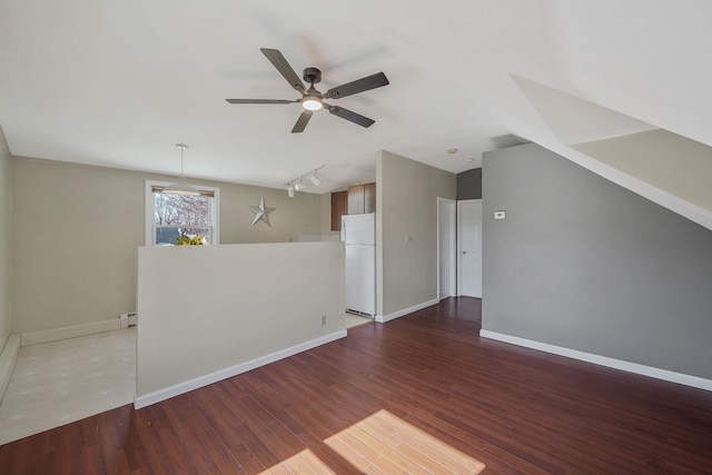 unfurnished room with track lighting, a baseboard heating unit, baseboards, and wood finished floors