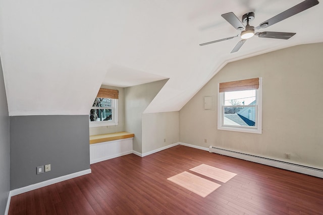 additional living space featuring baseboards, plenty of natural light, a baseboard heating unit, and hardwood / wood-style floors