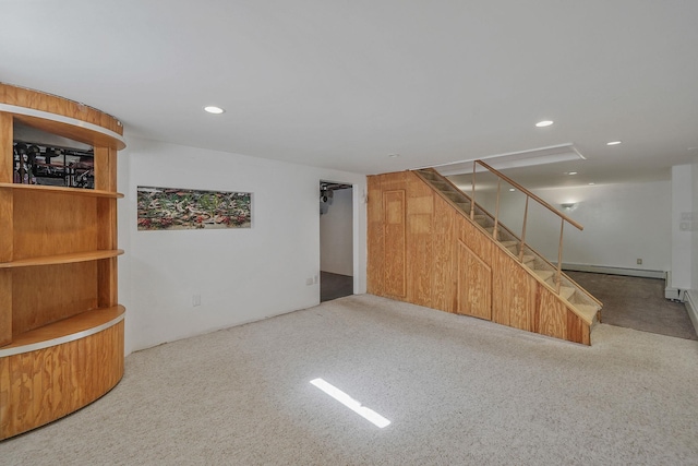 finished below grade area with carpet floors, recessed lighting, stairway, and a baseboard radiator