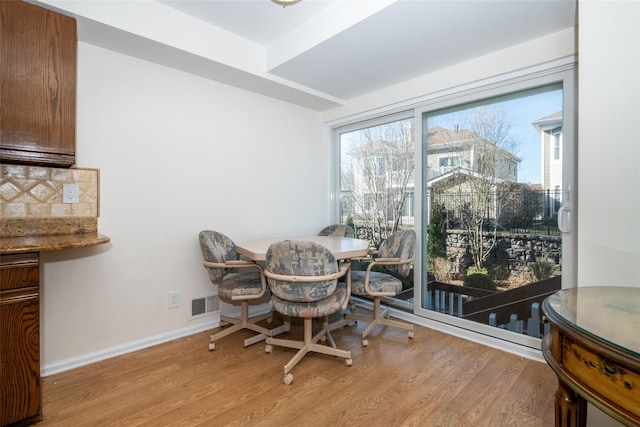 dining space featuring visible vents, light wood-type flooring, and baseboards