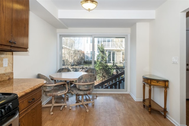 dining area with baseboards and light wood-type flooring
