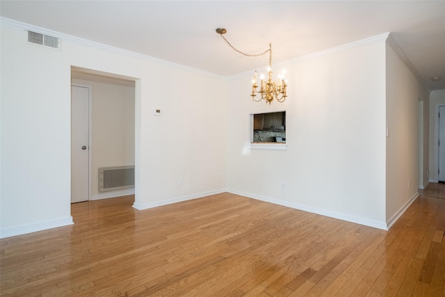 empty room with visible vents, an inviting chandelier, ornamental molding, and light wood finished floors