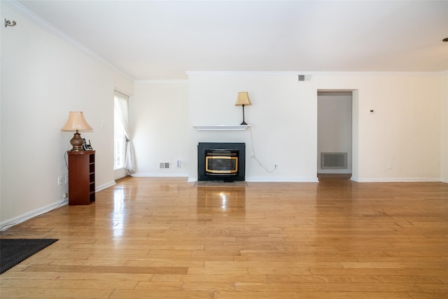 unfurnished living room featuring crown molding, light wood-style floors, visible vents, and baseboards