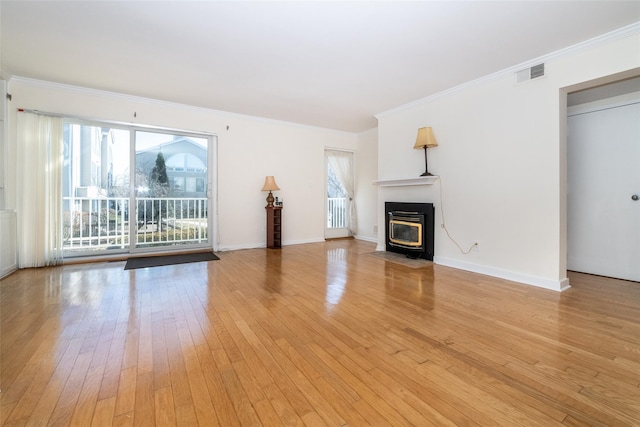 unfurnished living room with light wood-type flooring, visible vents, baseboards, and ornamental molding
