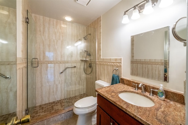 bathroom with vanity, toilet, and a stall shower