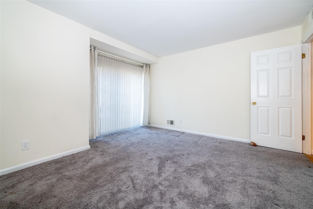 carpeted spare room with baseboards and visible vents