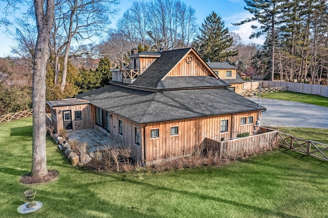 back of house with a yard, a chimney, fence private yard, and driveway