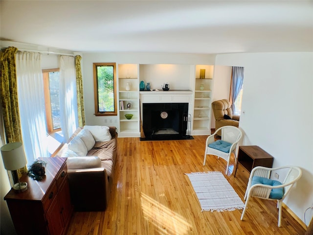 interior space featuring a fireplace with flush hearth and light wood finished floors