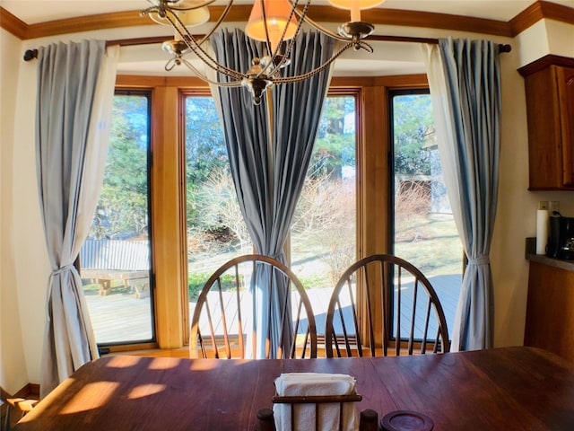 dining space with crown molding and a notable chandelier