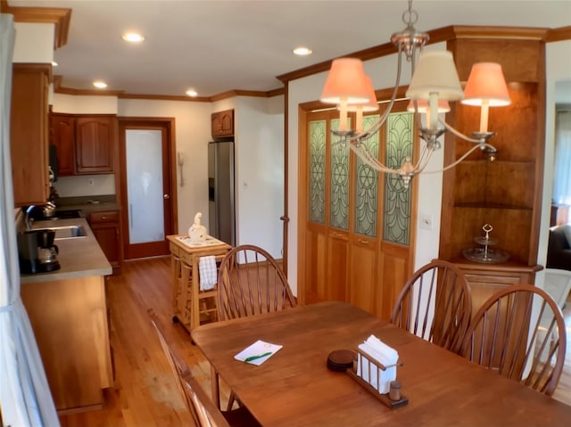 dining room featuring a chandelier, ornamental molding, recessed lighting, and light wood-style floors