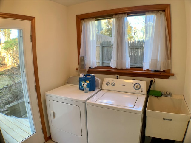 laundry room with laundry area, independent washer and dryer, a sink, and a healthy amount of sunlight