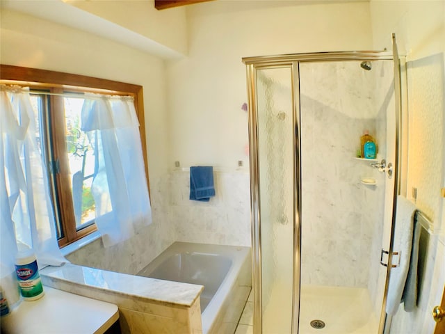 bathroom with a stall shower and a garden tub