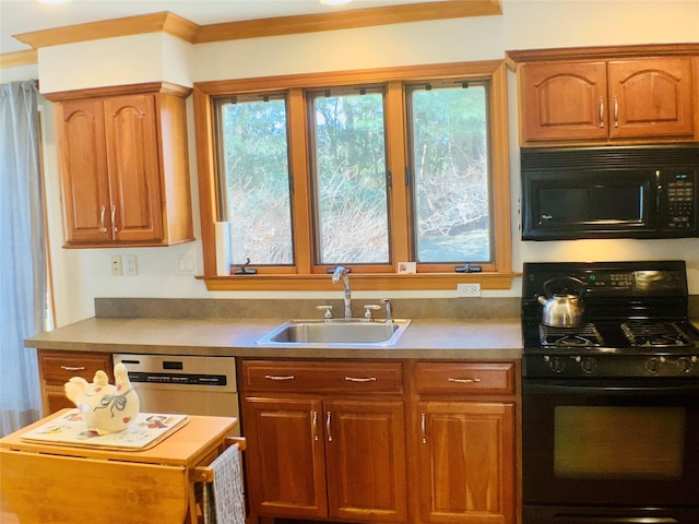 kitchen featuring brown cabinets, a healthy amount of sunlight, a sink, and black appliances