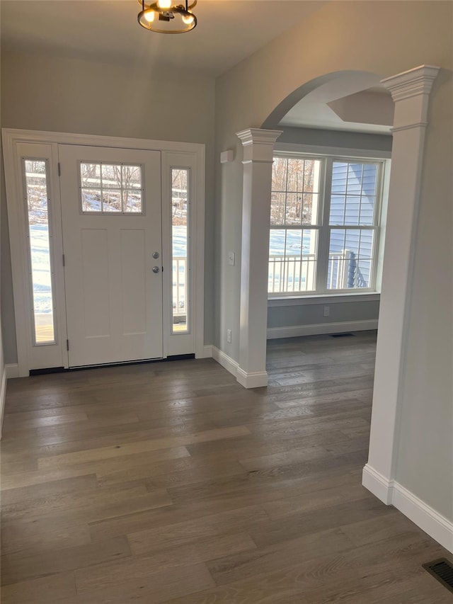 entryway with visible vents, decorative columns, baseboards, and wood finished floors