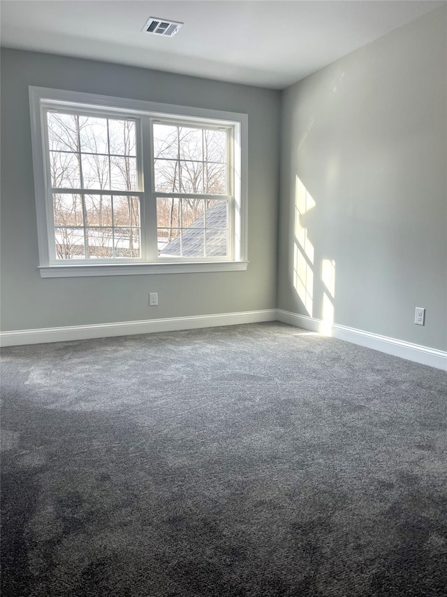 empty room featuring carpet, baseboards, and visible vents