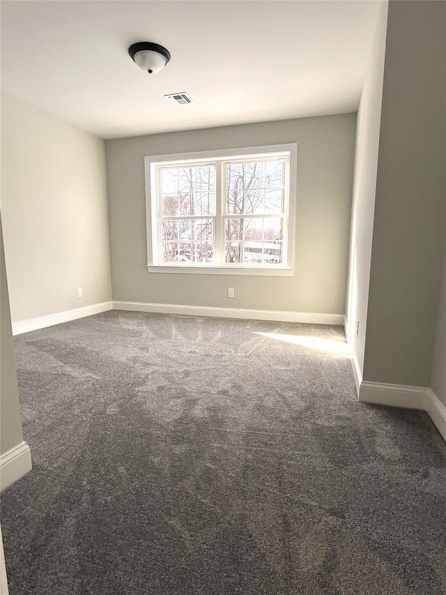 spare room featuring carpet flooring, visible vents, and baseboards