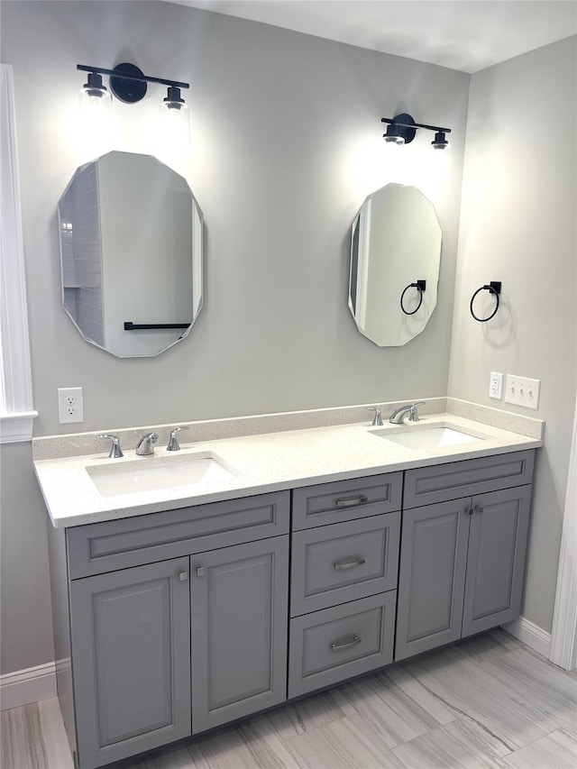 bathroom featuring a sink, baseboards, and double vanity