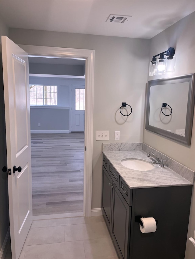 bathroom featuring visible vents, vanity, baseboards, and tile patterned floors