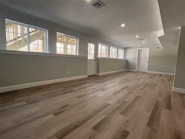 empty room featuring recessed lighting, wood finished floors, visible vents, and baseboards