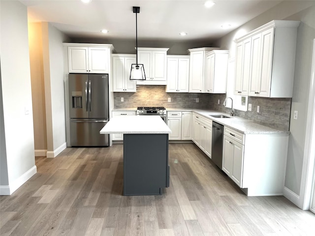 kitchen featuring white cabinetry, appliances with stainless steel finishes, backsplash, and a sink