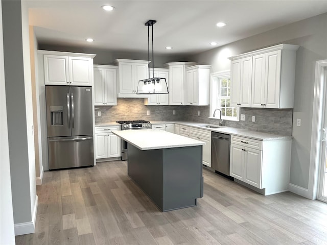 kitchen with appliances with stainless steel finishes, white cabinets, and a sink