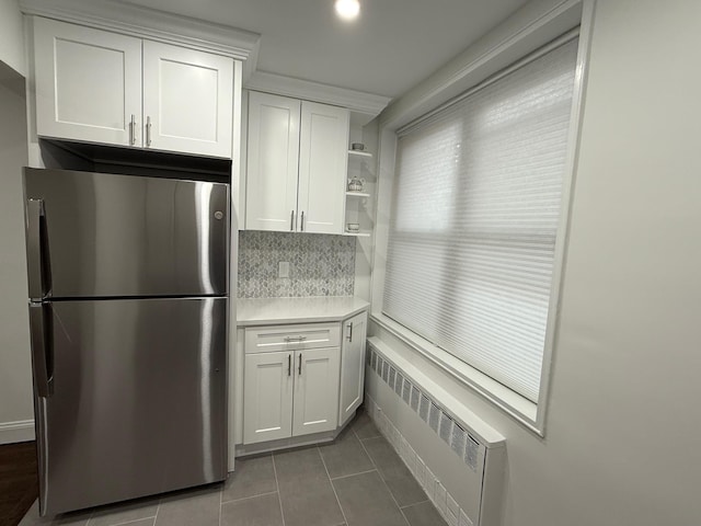 kitchen with white cabinetry, light countertops, freestanding refrigerator, radiator, and open shelves