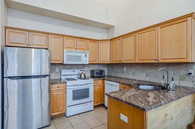 kitchen with white appliances, tasteful backsplash, a sink, and light tile patterned flooring