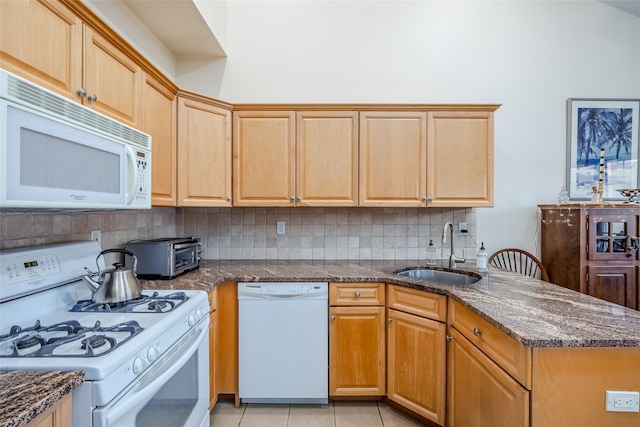 kitchen featuring light tile patterned floors, a toaster, white appliances, a sink, and tasteful backsplash