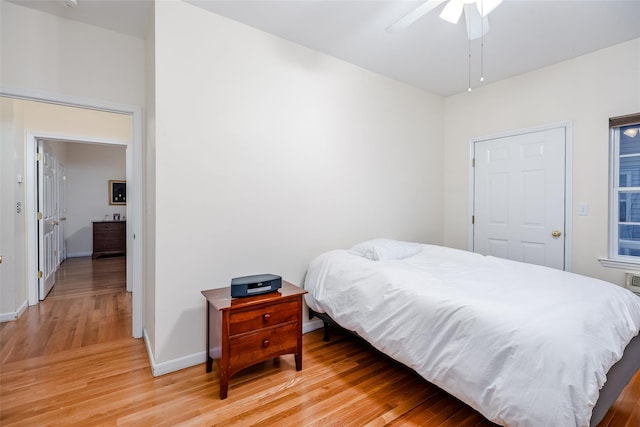 bedroom with ceiling fan, light wood finished floors, and baseboards