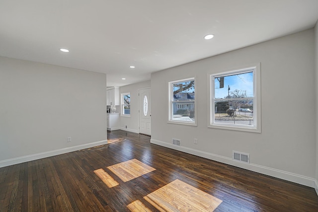 interior space with baseboards, visible vents, dark wood-style flooring, and recessed lighting