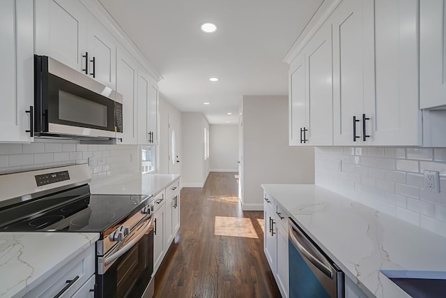 kitchen featuring baseboards, dark wood-style floors, appliances with stainless steel finishes, light stone countertops, and white cabinetry