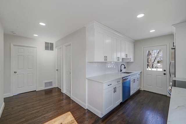 kitchen with tasteful backsplash, visible vents, dishwashing machine, dark wood-type flooring, and white cabinetry