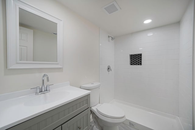 bathroom featuring recessed lighting, visible vents, toilet, vanity, and tiled shower