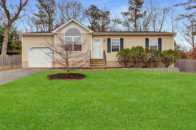 ranch-style house featuring driveway, a front lawn, an attached garage, and fence