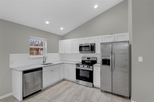 kitchen with appliances with stainless steel finishes, white cabinets, light countertops, and a sink