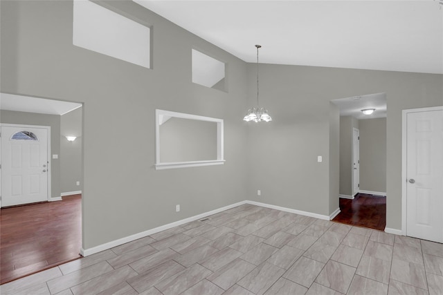 interior space with a chandelier, high vaulted ceiling, light wood-style flooring, and baseboards