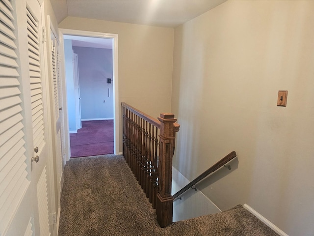 hallway with carpet, baseboards, and an upstairs landing