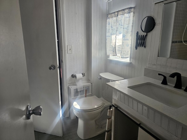 bathroom with toilet, vanity, and radiator heating unit