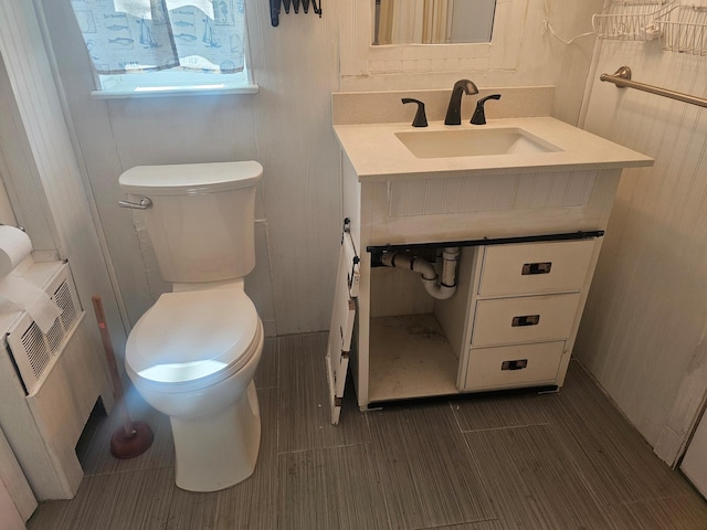 bathroom featuring wood tiled floor, vanity, and toilet