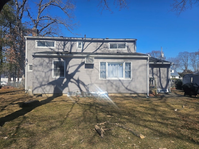 rear view of property featuring a lawn