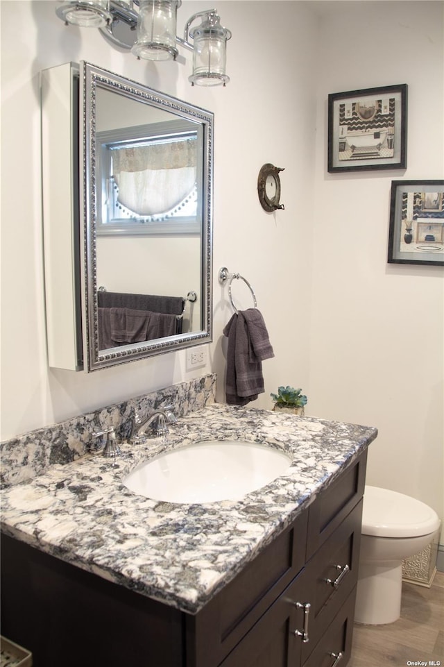 74 Wisconsin St, Long Beach, NY 11561 - half bathroom featuring toilet, vanity, and wood finished floors