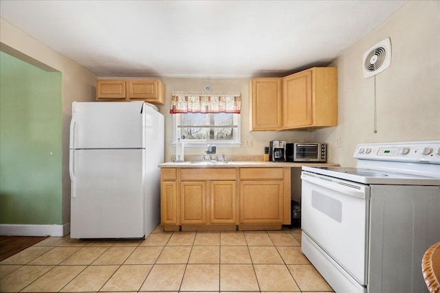 kitchen featuring light brown cabinets, a toaster, white appliances, visible vents, and light countertops